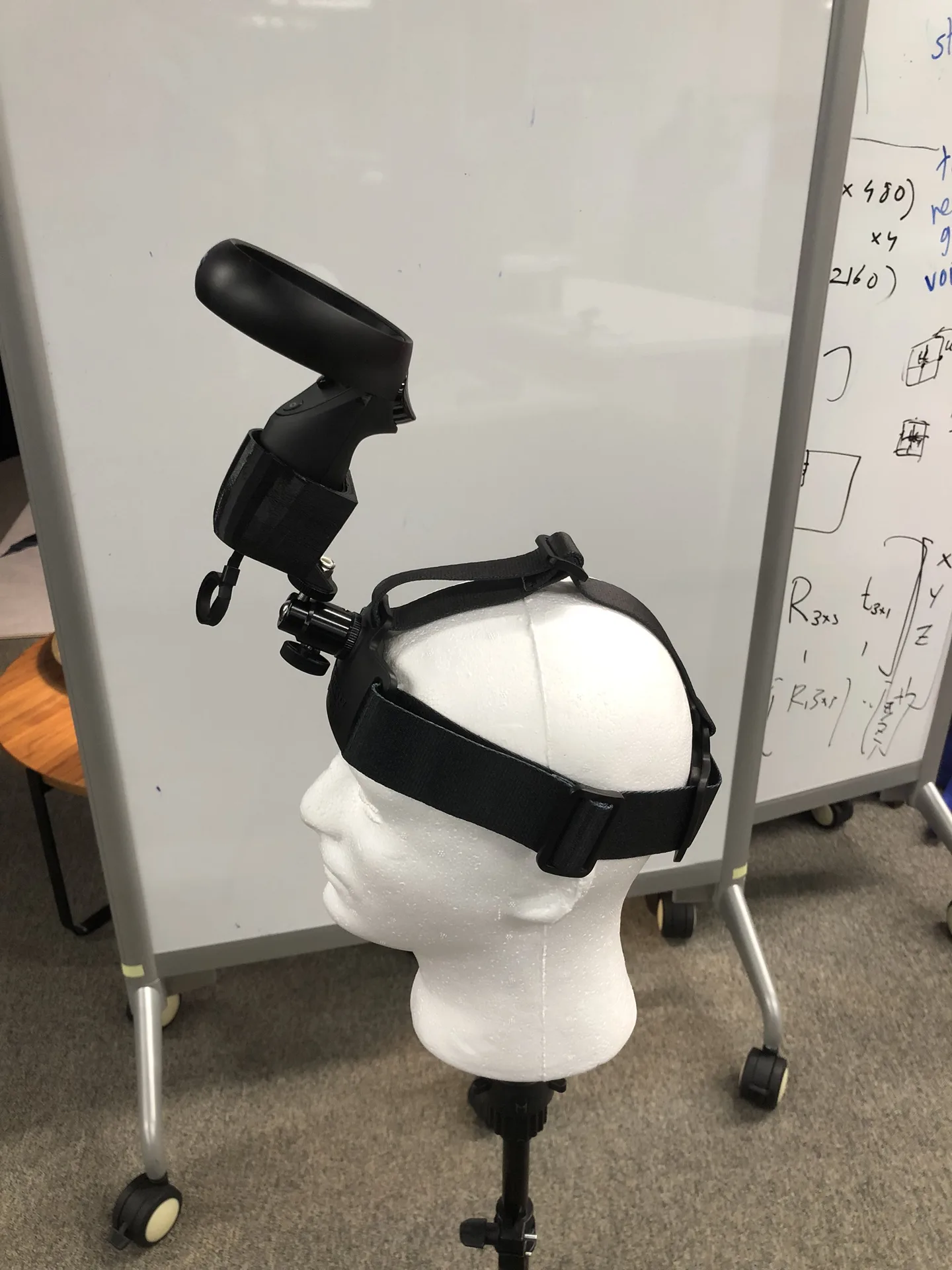 Side view of the mannequin head with the controller held upright on a printed mount on the head strap.